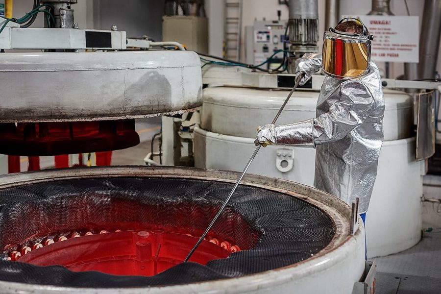 Fotografia przemysłowa - Pracownik w ochronnym ubraniu obsługuje wirówkę chemiczną.