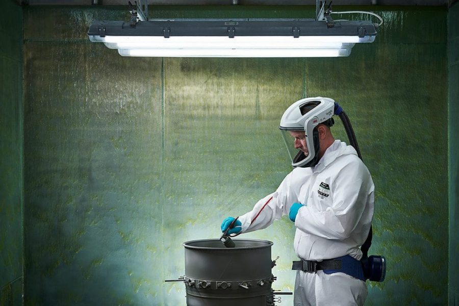 Zdjęcia przemysłowe Rzeszów - Pracownik maluje element w bezpiecznym środowisku.