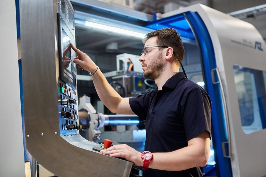 Fotografia przemysłowa Rzeszów - operator maszyny obsługujący sprzęt CNC w zakładzie.